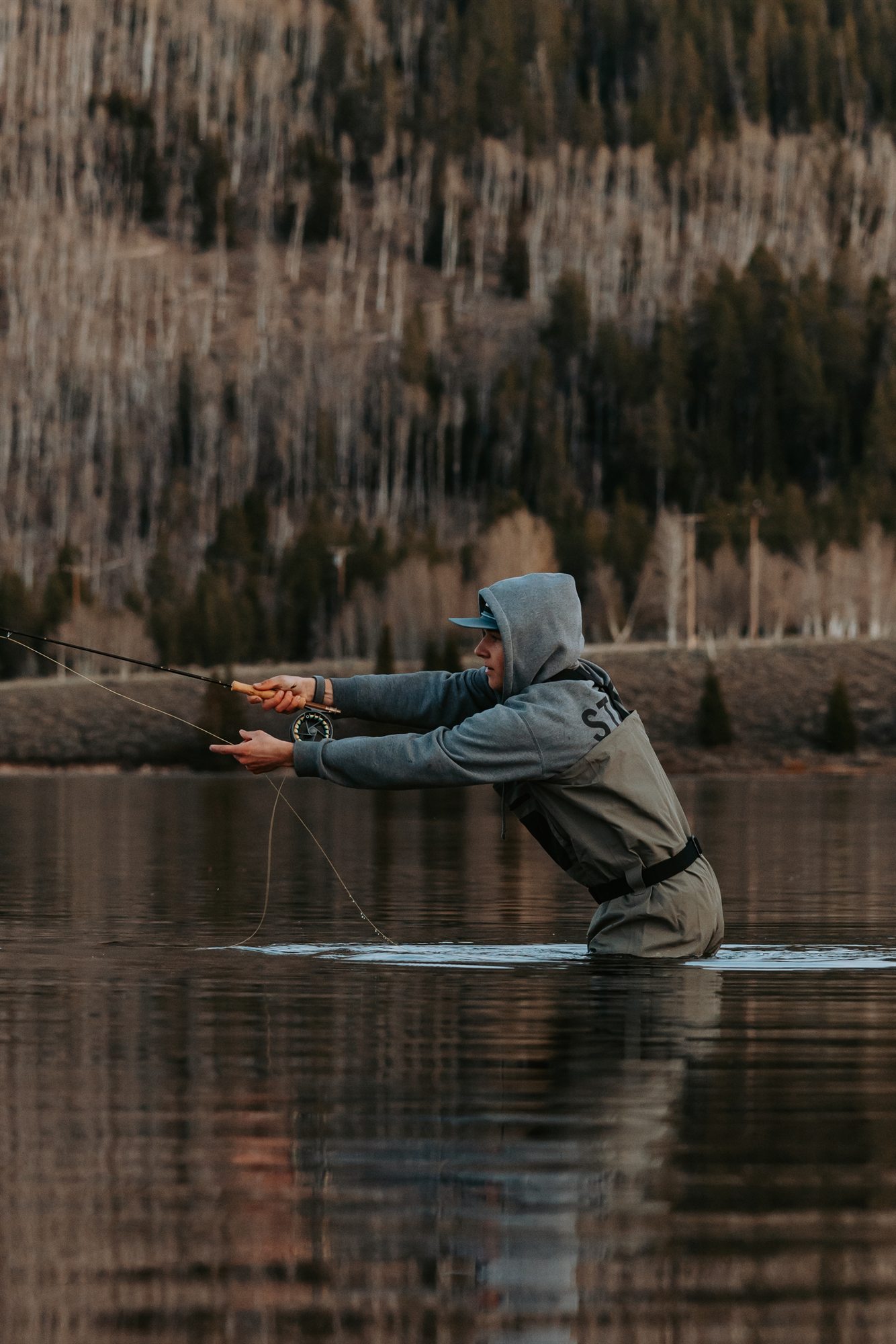Angler casting a fly line on the water