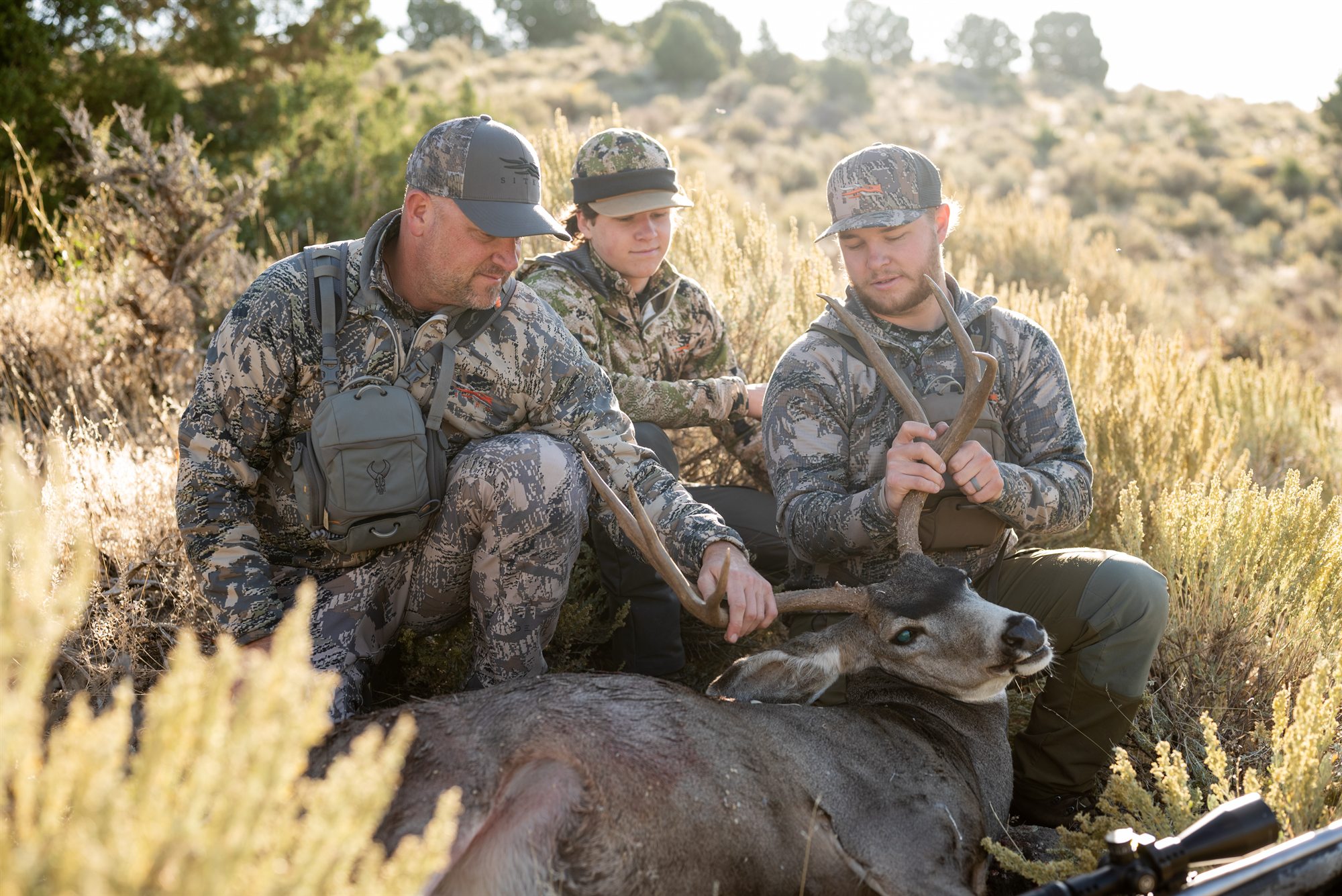 Outdoorsmen gathered around a harvest in the field