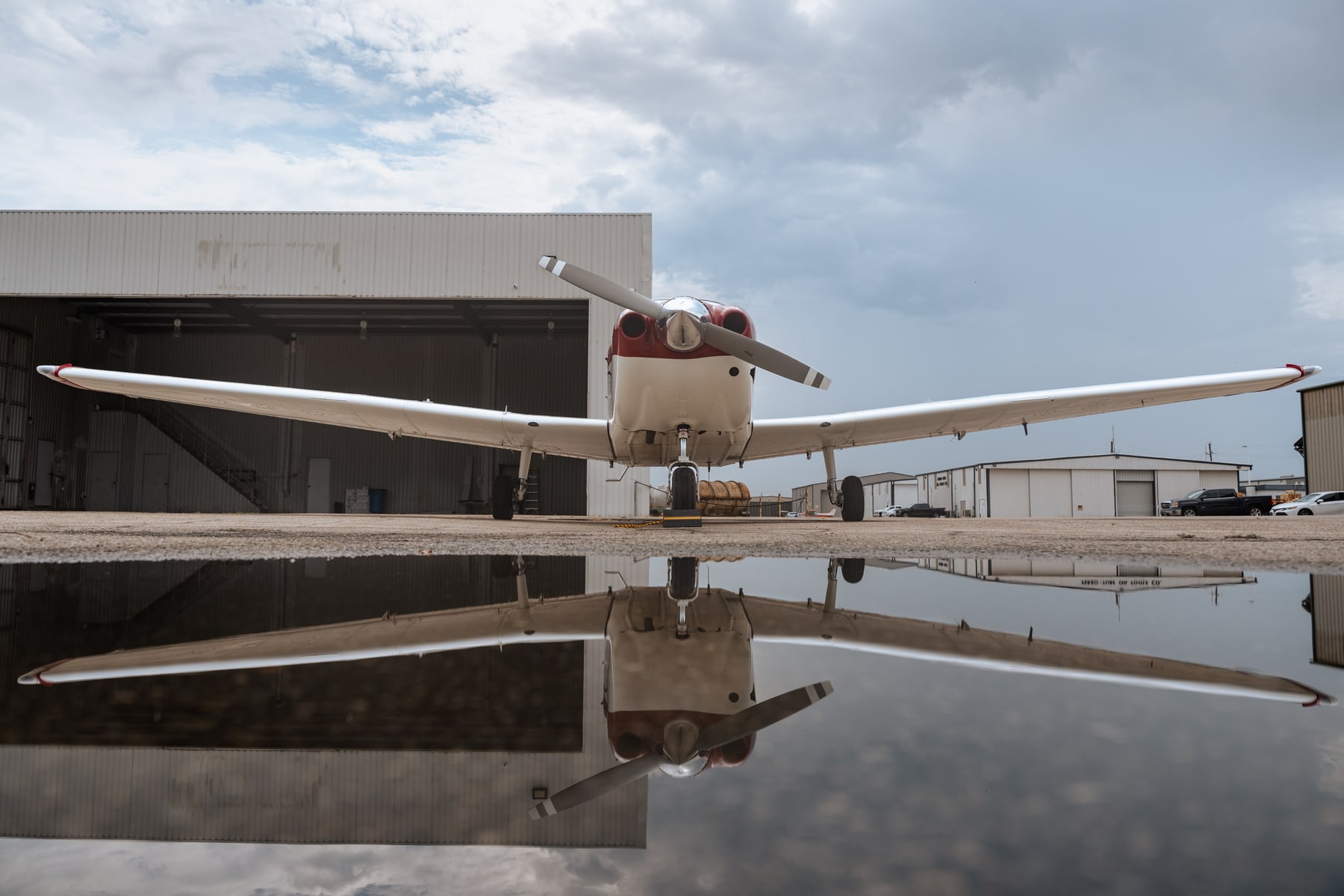 Texas Flight Airline Academy aircraft reflected on the apron outside a hangar